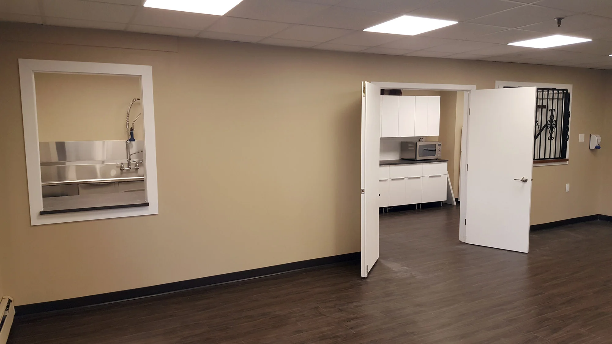 The open community room in Calgary with the food pass-through window and its new wrought-iron gate, August 2017