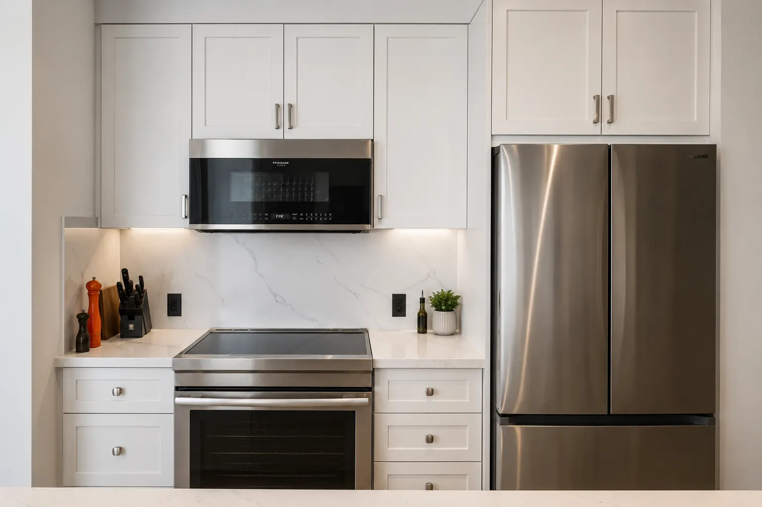 Kitchen renovation in Spruce Cliff, Calgary — shaker cabinets with a full-height marble-look slab backsplash