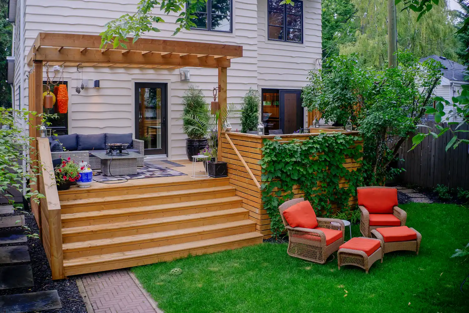 Mount Royal backyard after renovation — a multi-level cedar deck with a pergola and privacy screens, Calgary