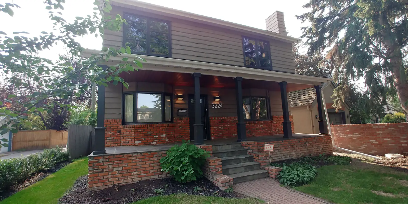 Mount Royal home before renovation — dated taupe siding and a red-brick front porch, Calgary