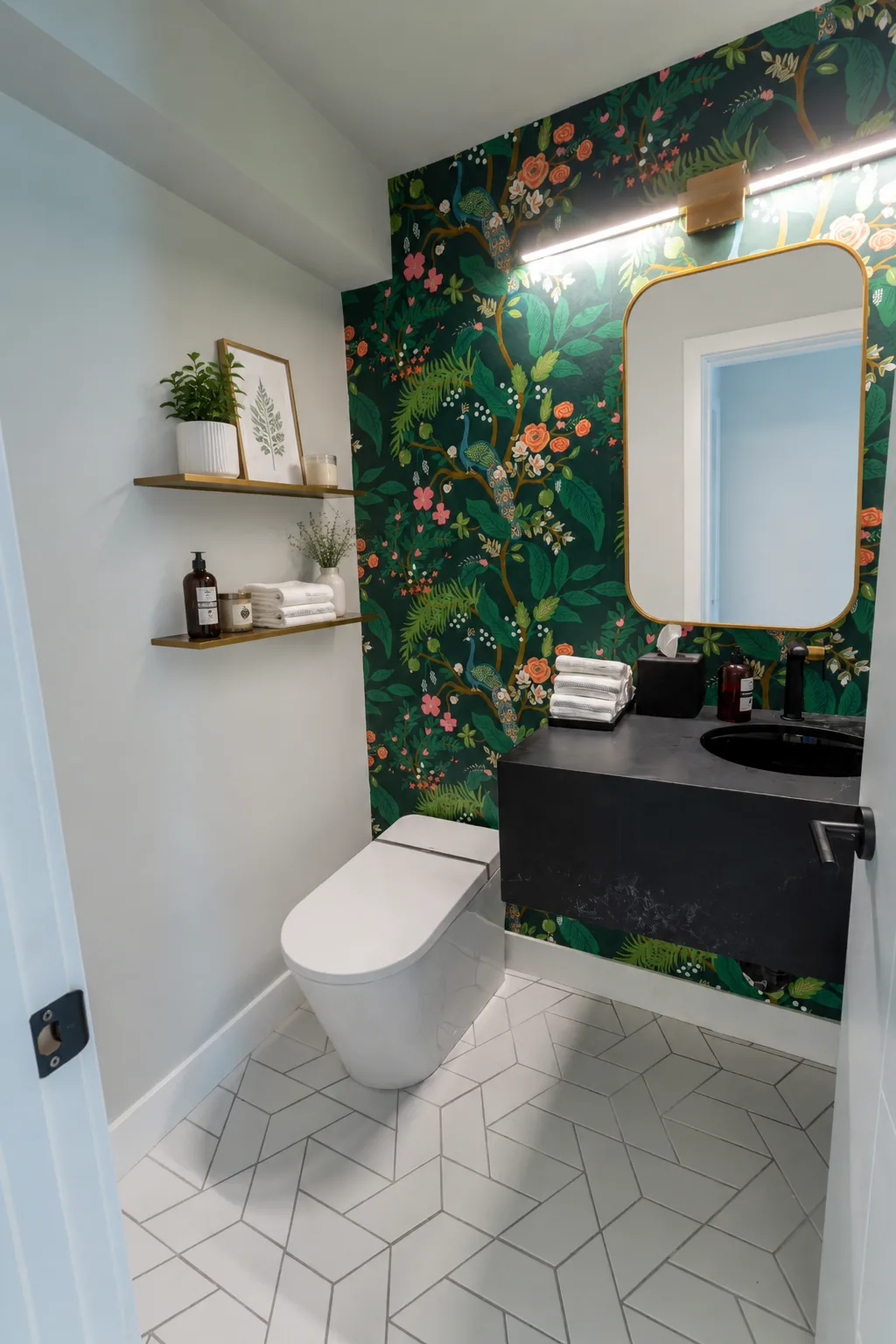 Rideau powder room after renovation — a dark-green botanical wallpaper wall, a floating black-stone vanity with a matte-black faucet and brass accents, Calgary