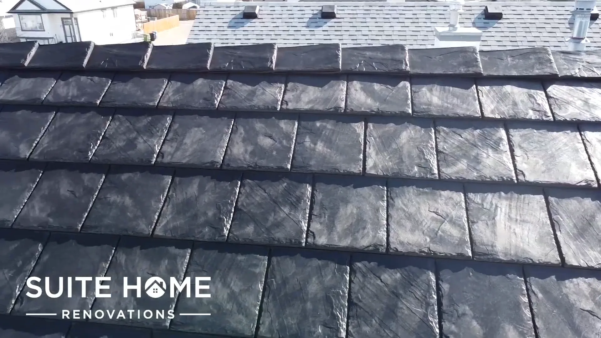 Close aerial of dark charcoal EuroShield rubber slate laid in courses on a Calgary roof