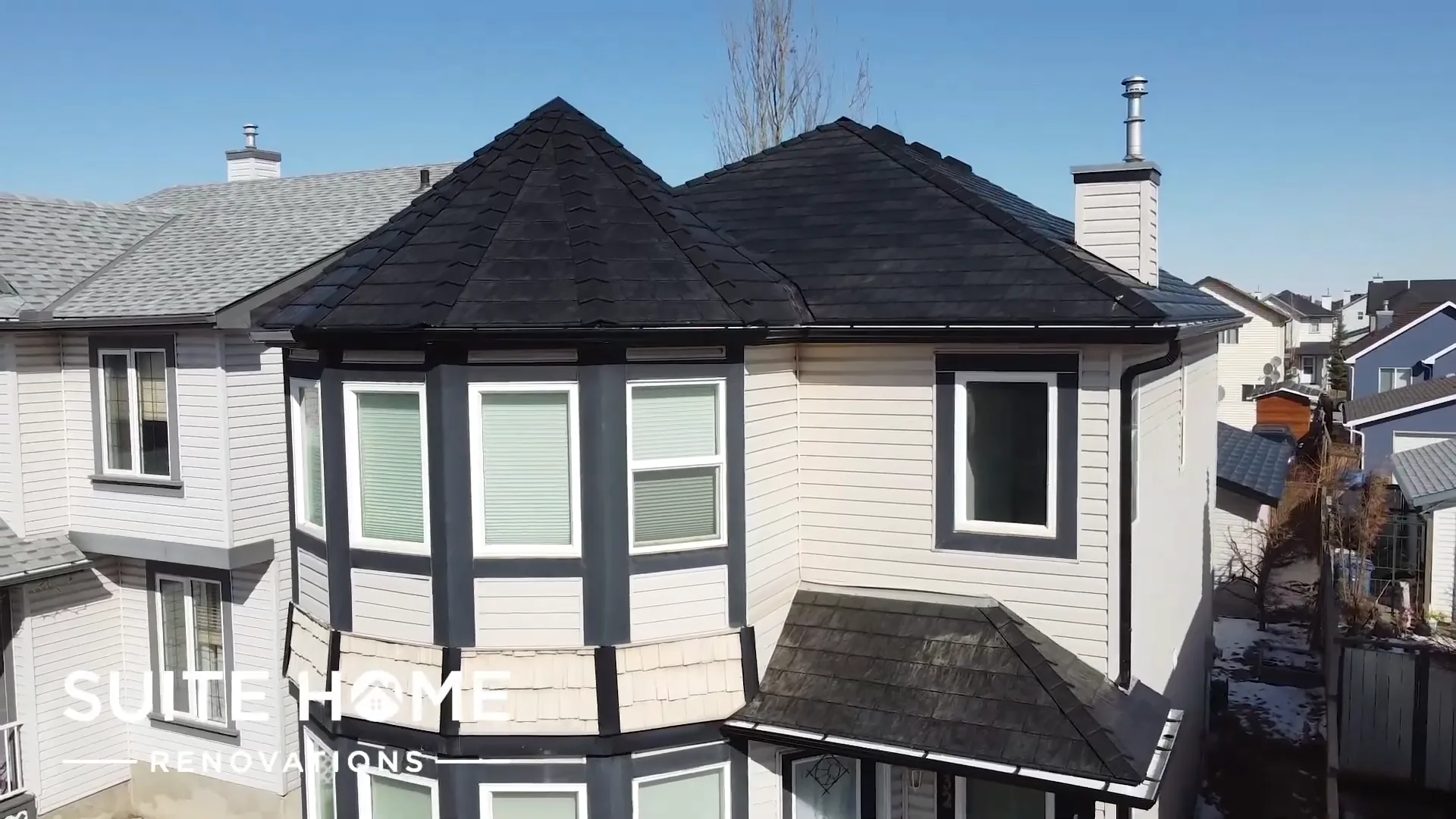 Aerial view of a completed rubber slate roof and eight sided turret on a two storey Calgary home
